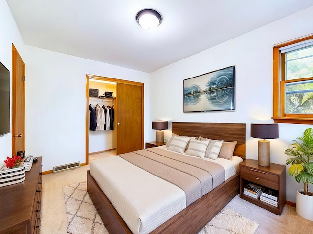 bedroom with light colored carpet, a closet, visible vents, and baseboards