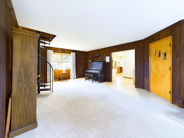 unfurnished living room featuring light colored carpet and wooden walls