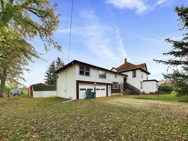 rear view of property with a yard and a garage