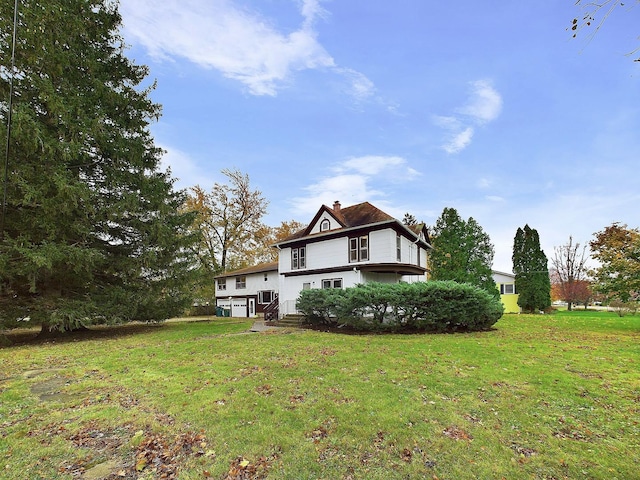 rear view of house featuring a chimney and a lawn