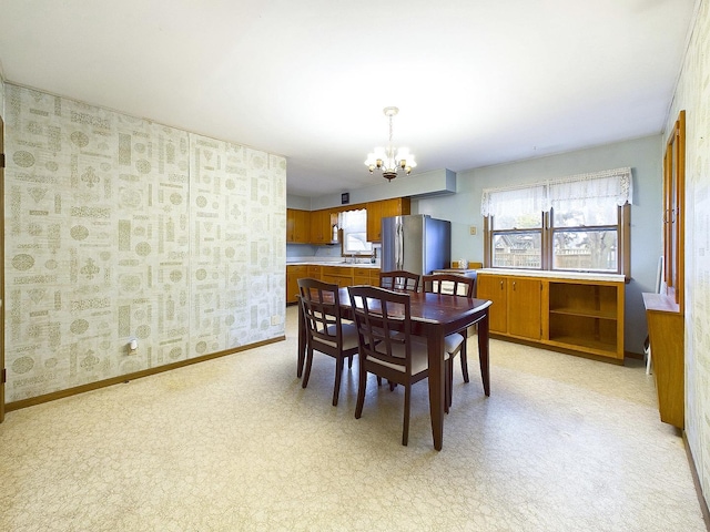 dining space featuring baseboards and an inviting chandelier