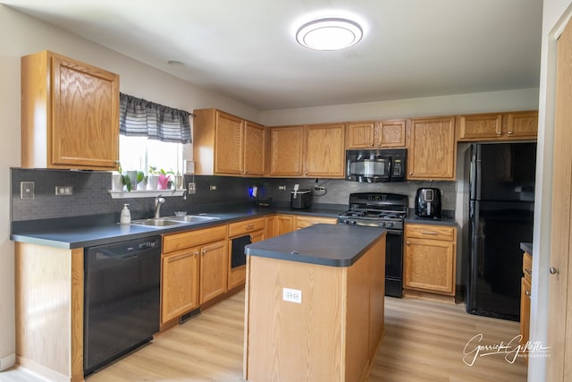 3616 Thomas Ct, Plano, IL 60545 - kitchen featuring black appliances, a sink, light wood-style flooring, a center island, and backsplash