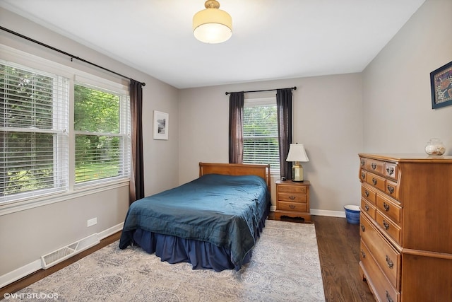 bedroom featuring dark hardwood / wood-style floors and multiple windows