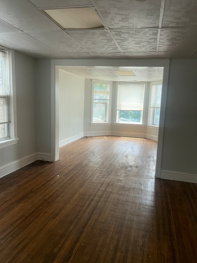 unfurnished room featuring dark hardwood / wood-style floors and a healthy amount of sunlight