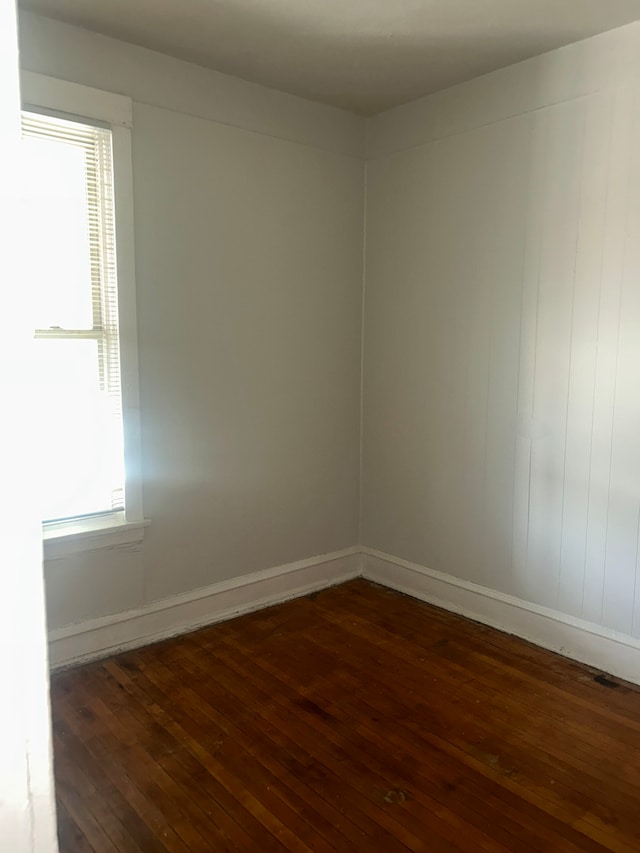 unfurnished room featuring a wealth of natural light and dark hardwood / wood-style flooring