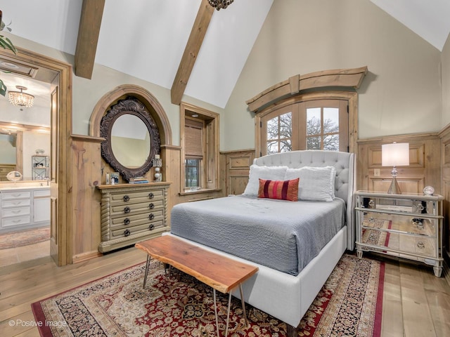 bedroom with beam ceiling, ensuite bathroom, light hardwood / wood-style flooring, and high vaulted ceiling