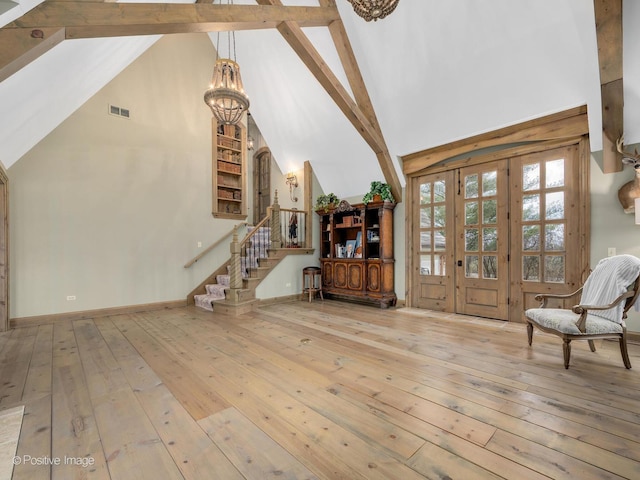 interior space featuring beamed ceiling, a notable chandelier, light hardwood / wood-style floors, and high vaulted ceiling