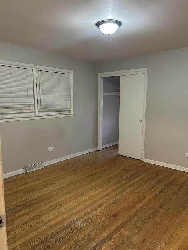 unfurnished bedroom featuring a closet and hardwood / wood-style floors