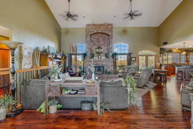 living area with dark wood-style floors, ceiling fan, and high vaulted ceiling