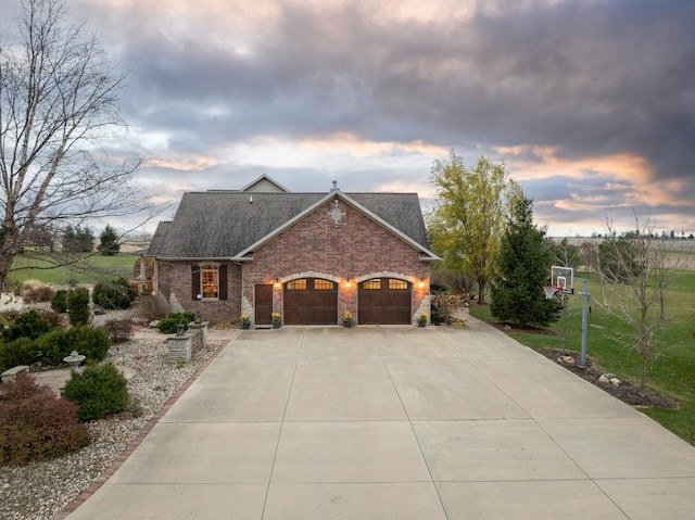 view of front of house with concrete driveway, brick siding, and roof with shingles