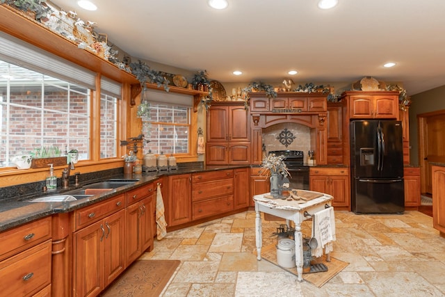 kitchen with recessed lighting, stone tile flooring, a sink, and black appliances