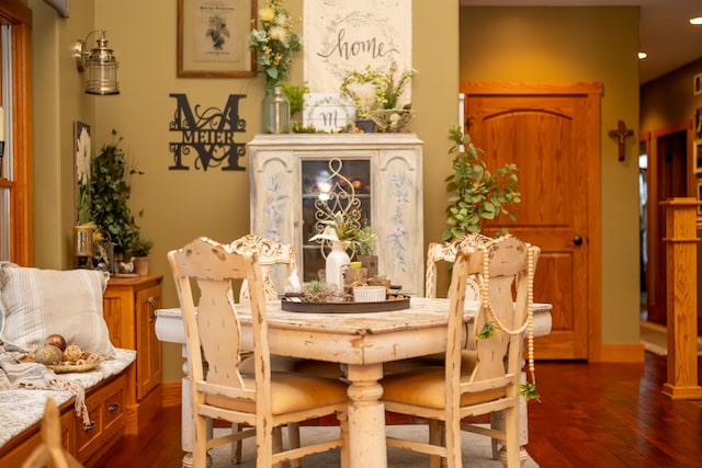 dining area with dark wood-style flooring and baseboards