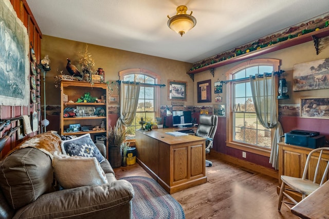 office space with visible vents, light wood-style flooring, and baseboards