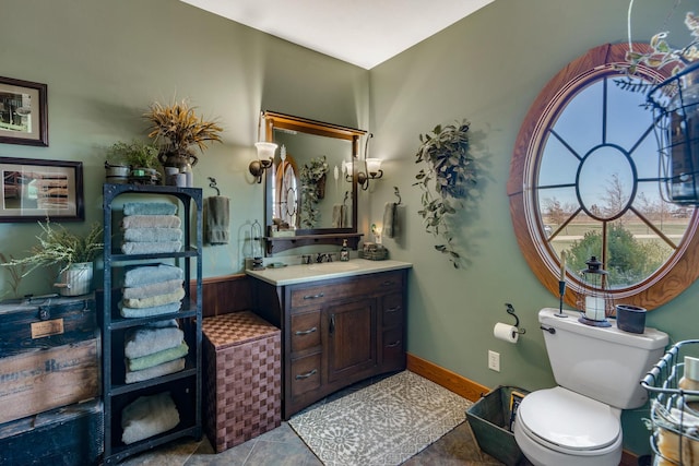 bathroom with toilet, tile patterned flooring, vanity, and baseboards