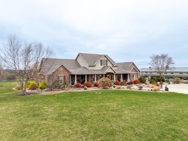 view of front facade with a front lawn, a porch, and brick siding