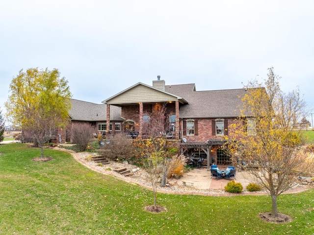 rear view of house with a chimney, a lawn, a pergola, and brick siding