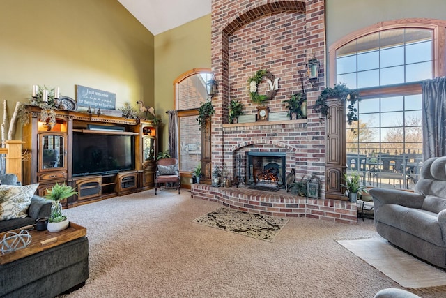 living area with a fireplace, high vaulted ceiling, and carpet flooring