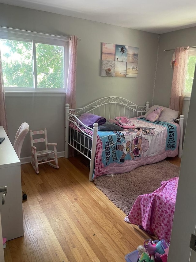 bedroom featuring hardwood / wood-style floors and multiple windows