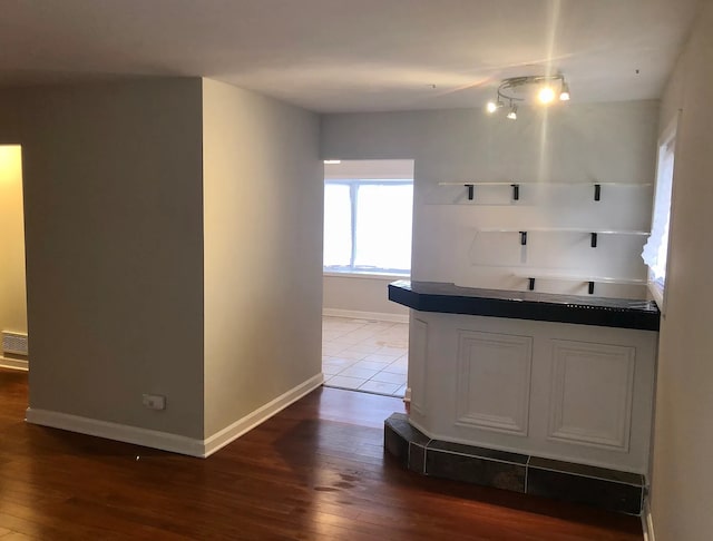 bar with dark wood-style floors, visible vents, and baseboards