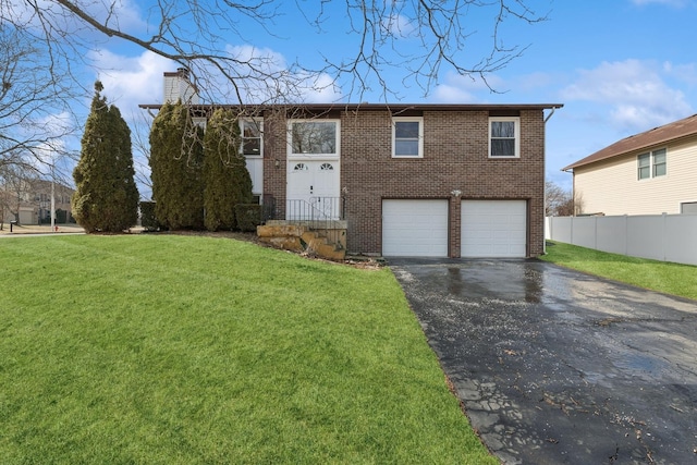 split foyer home featuring a garage and a front lawn