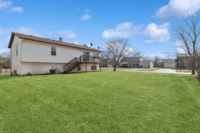 back of property with a garage, a yard, a deck, and central air condition unit