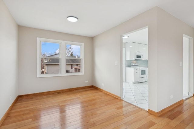 unfurnished room with light wood-type flooring