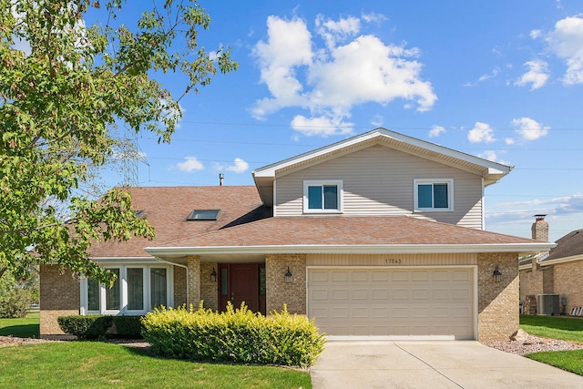 view of front of property featuring a garage, central air condition unit, and a front yard