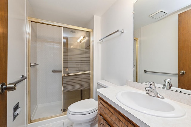 bathroom with tile patterned floors, vanity, toilet, and a shower with shower door