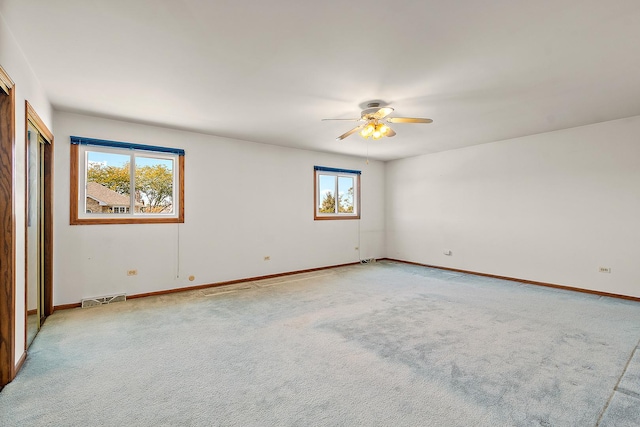 carpeted spare room featuring ceiling fan