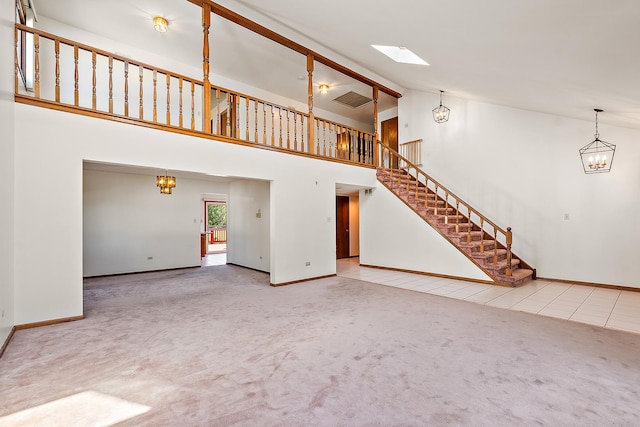 unfurnished living room featuring carpet flooring and high vaulted ceiling