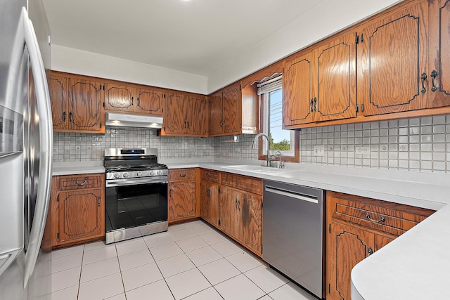 kitchen featuring tasteful backsplash, sink, light tile patterned floors, and stainless steel appliances