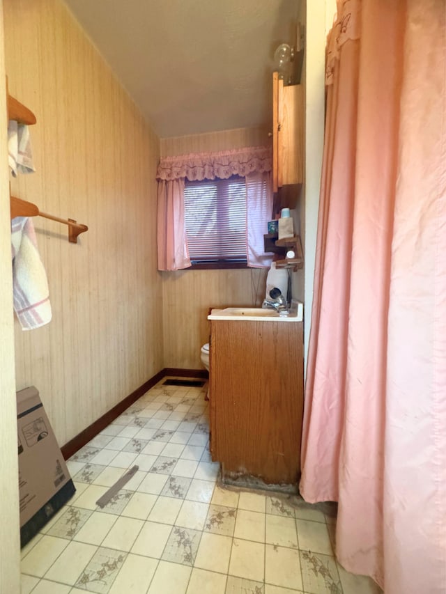 bathroom with toilet and wooden walls