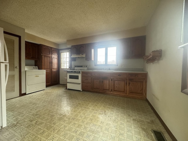 kitchen with sink, white range, ventilation hood, a textured ceiling, and washer / dryer