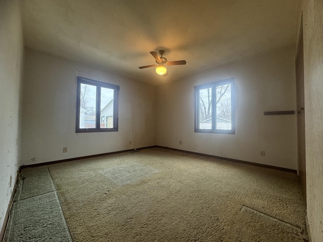 unfurnished room with ceiling fan and carpet