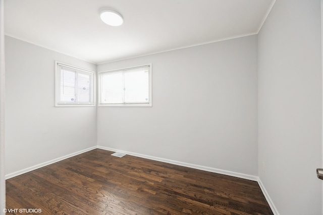 unfurnished room featuring dark hardwood / wood-style floors and ornamental molding