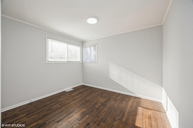 spare room featuring ornamental molding and dark wood-type flooring