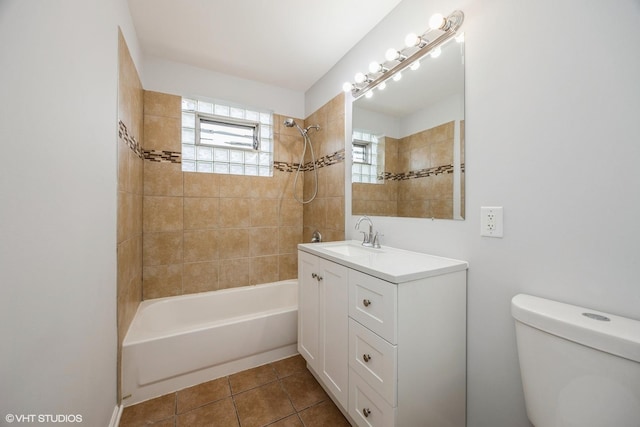 full bathroom with tile patterned floors, vanity, tiled shower / bath combo, and toilet