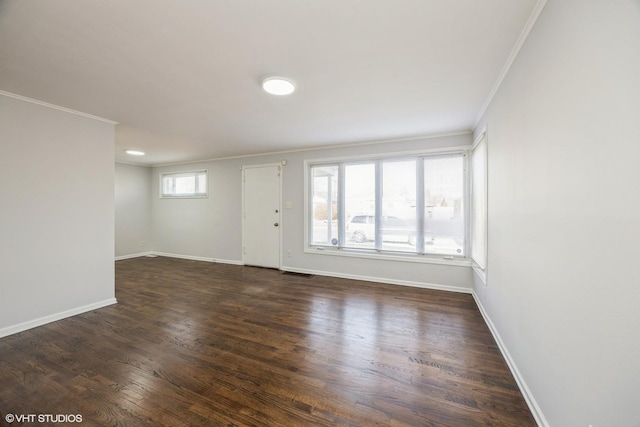 spare room with crown molding and dark wood-type flooring