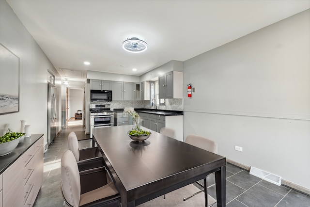 dining space with dark tile patterned floors and sink