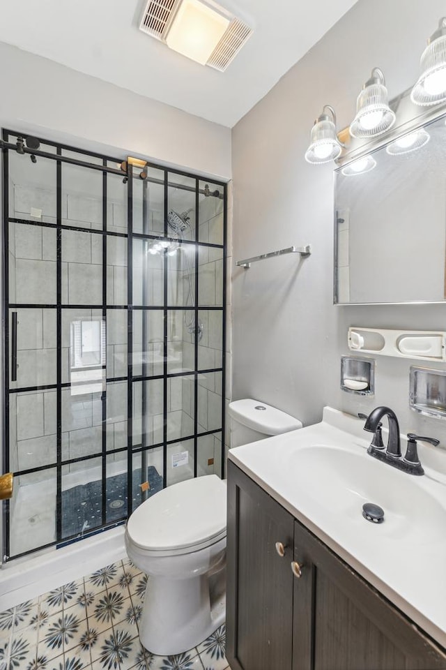 bathroom with vanity, toilet, and a tile shower