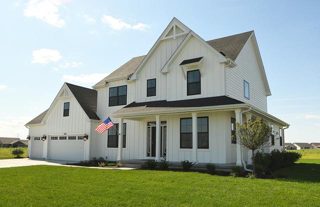 modern inspired farmhouse featuring a front lawn and a garage