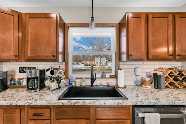 kitchen featuring sink, decorative backsplash, stainless steel dishwasher, and hanging light fixtures