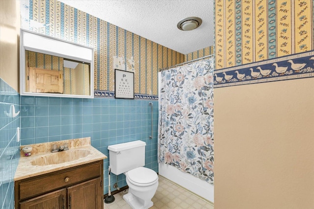 bathroom with tile walls, vanity, a textured ceiling, toilet, and walk in shower