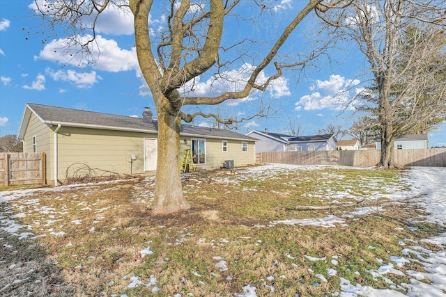 snow covered back of property featuring central AC