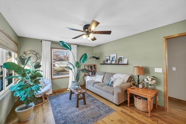 living room with a textured ceiling, light hardwood / wood-style flooring, and ceiling fan