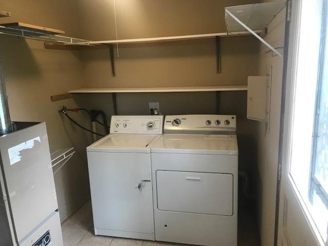 laundry room featuring laundry area, light tile patterned floors, and independent washer and dryer