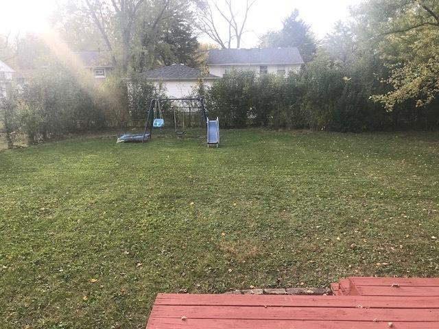 view of yard featuring a trampoline and a playground