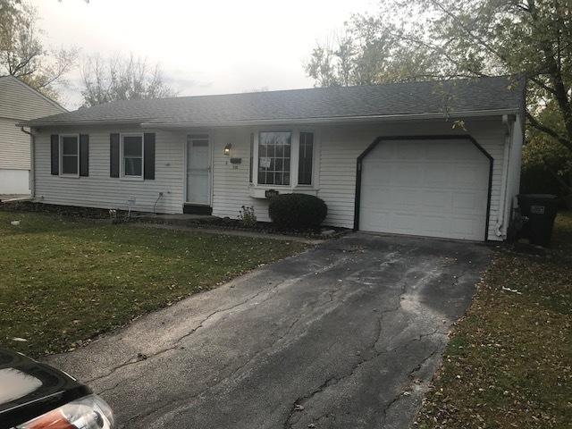 ranch-style home with driveway, an attached garage, and a front yard