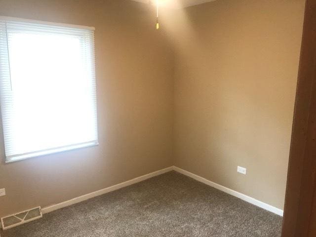 unfurnished room with carpet flooring, visible vents, and baseboards