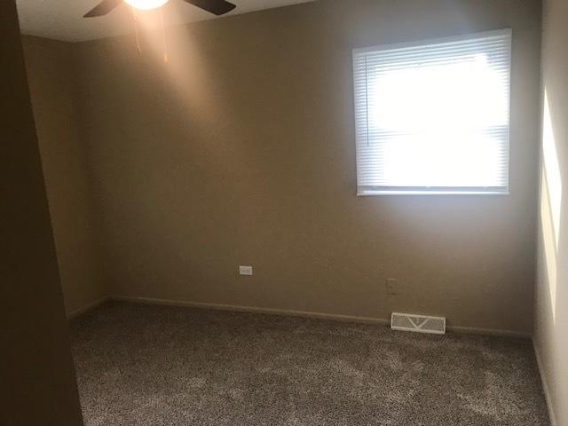 unfurnished room with visible vents, ceiling fan, and carpet flooring